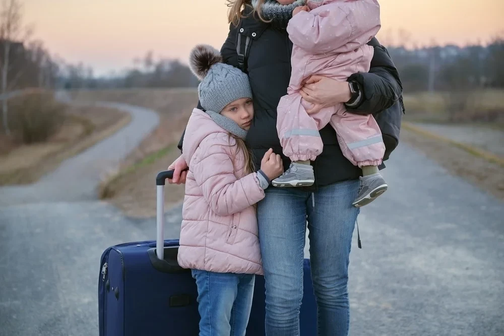 Отпуск многодетным родителям в 2024. Фото черно-белое беженцы женщина с ребенком в платках с чемоданами. Фото беженцы женщина с ребенком в платках с чемоданами.