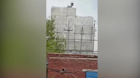 Падение экскаватора с высоты во время демонтажа здания.